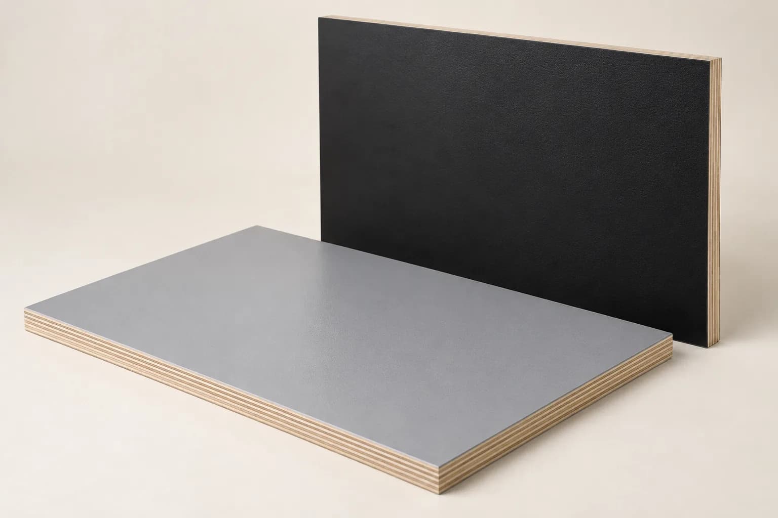 Grey and black plastic-faced plywood panels with continuous coated surfaces and layered cut edges