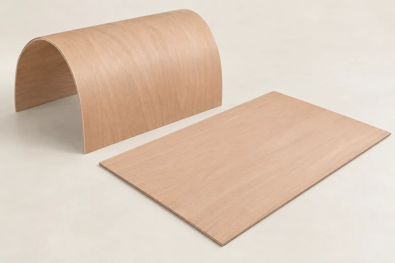 Flexible plywood sheets with continuous okoume veneer faces, one formed into a broad curve and one lying flat